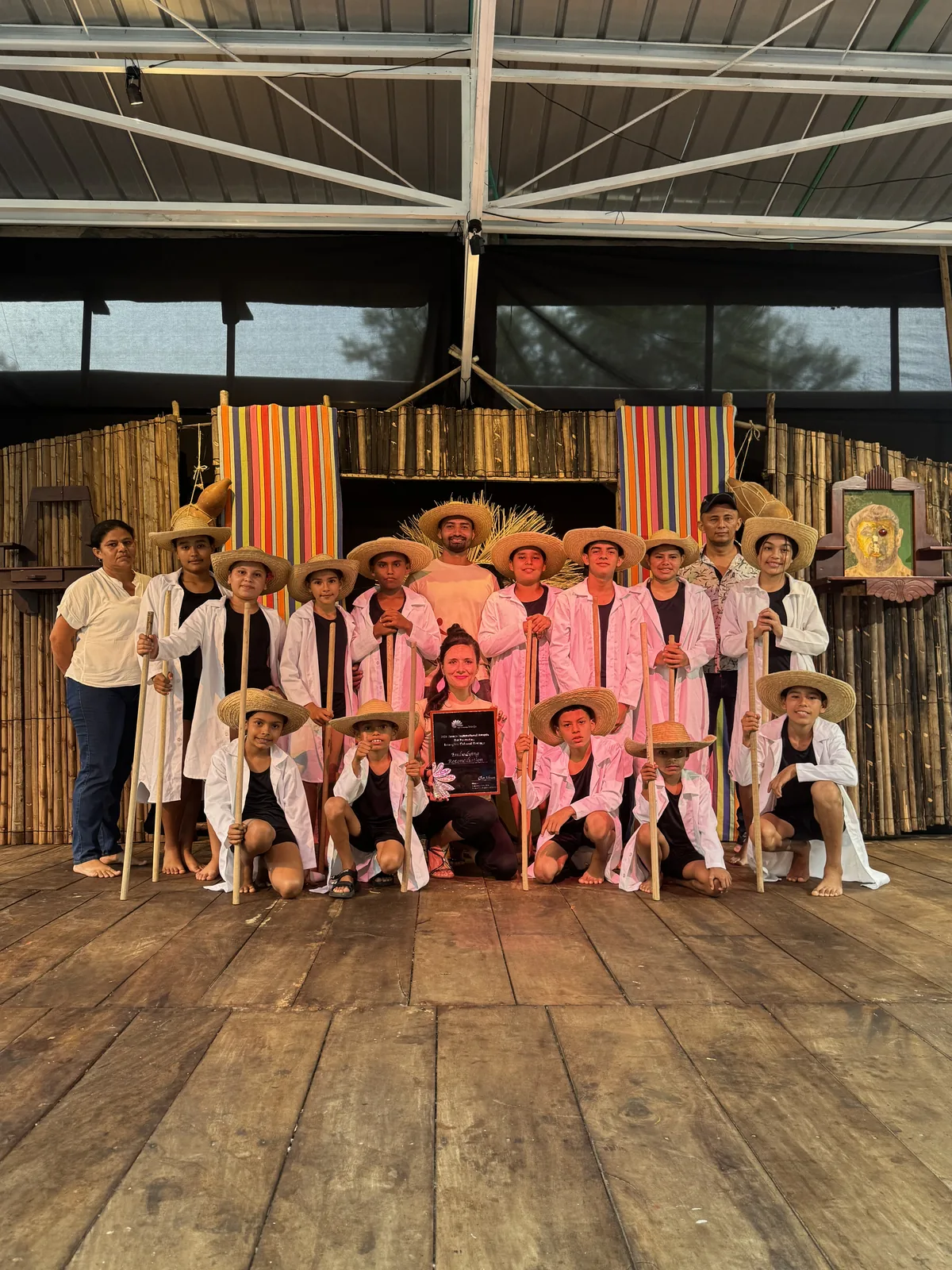 Young dancers in white with straw hats and the JIAPICH award.
